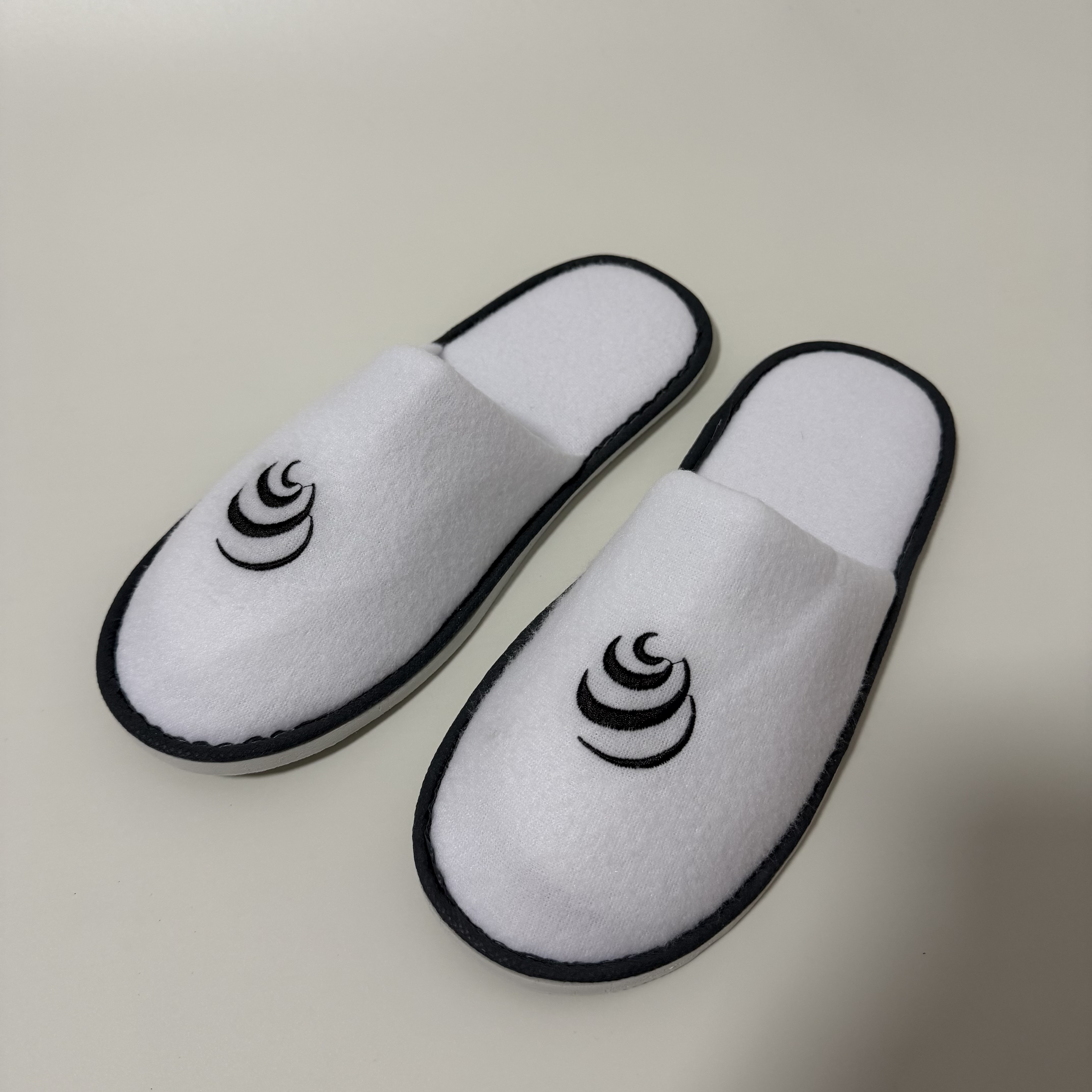 Custom White Terry Closed Toe Hotel Slippers Manufacturer | Wholesale Black Embroidered Logo Hospitality Slippers