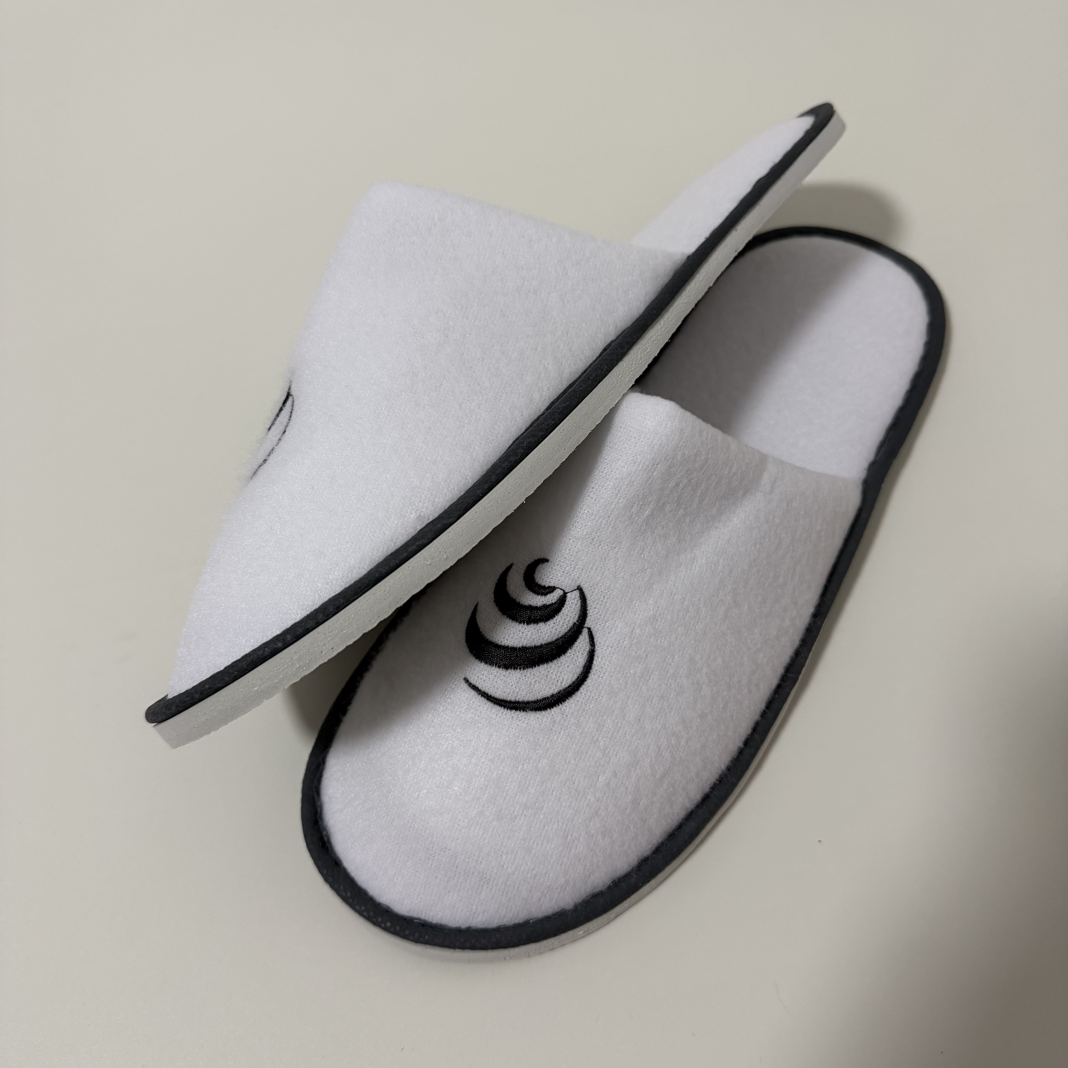 Custom White Terry Closed Toe Hotel Slippers Manufacturer | Wholesale Black Embroidered Logo Hospitality Slippers